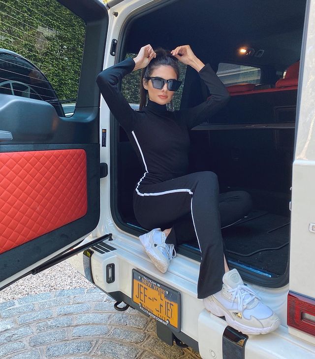Paige DeSorbo in a full black fitness attire and black goggles sitting in her car.